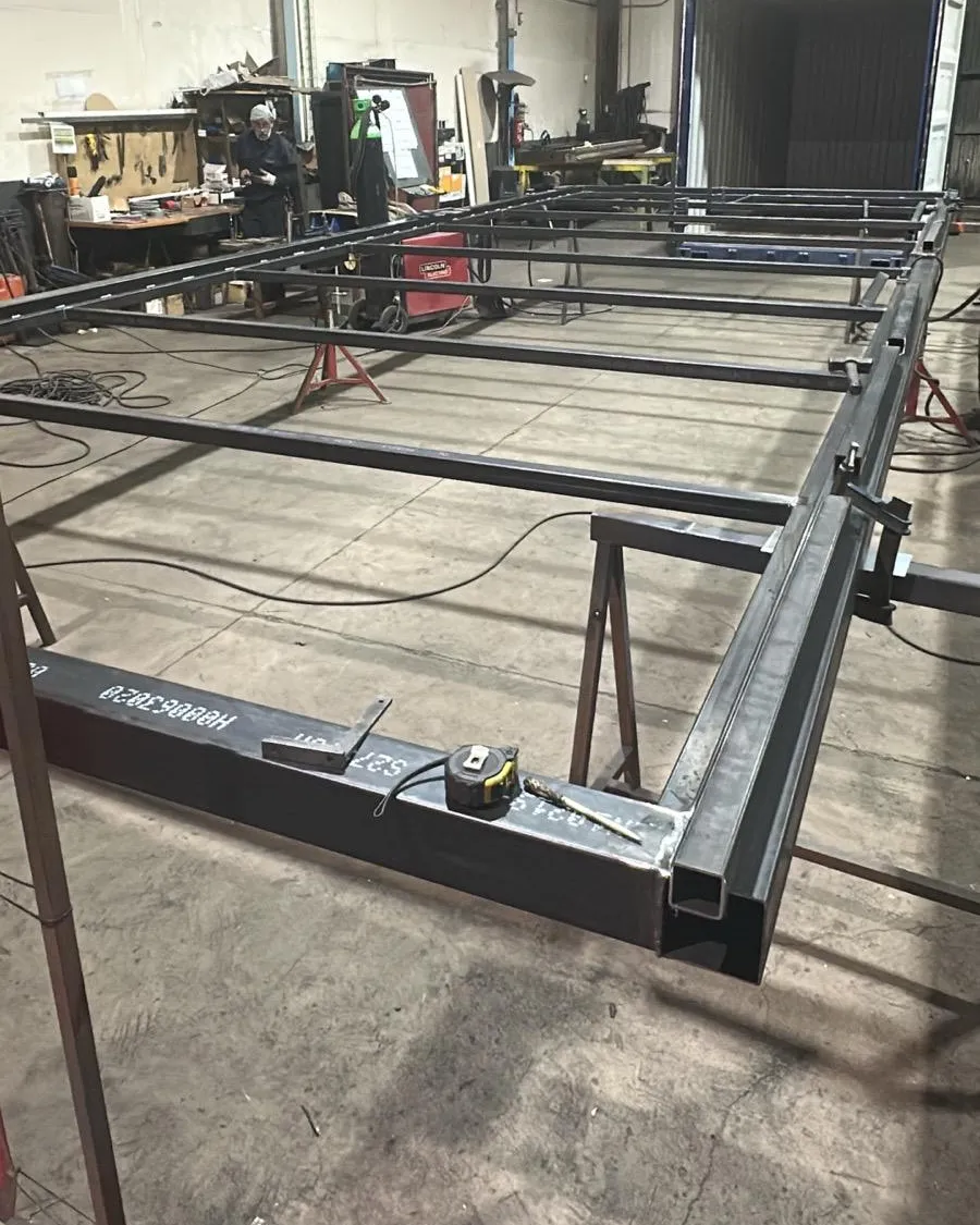 Estructura de acero de un módulo en el taller de Huelva, con una cinta métrica sobre el perfil para el control dimensional