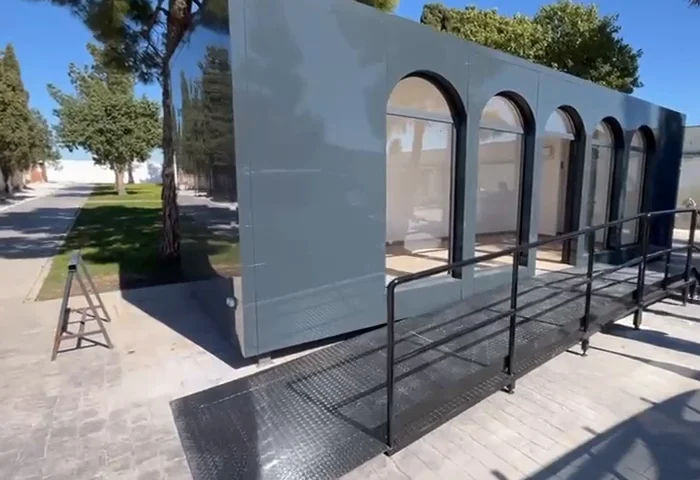 Módulo prefabricado en su ubicación: fachada de panel con huecos en arco y rampa de acceso